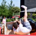 A young man enjoys a thrilling ride on a mechanical bull during a park event in London.